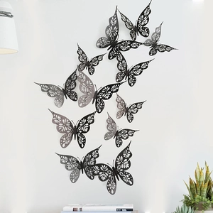 Detailed view of 3D black cutout butterflies with floral patterns on a white wall