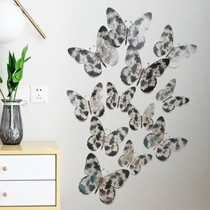 3D hollow paper butterflies with floral patterns displayed as wall decor in a living room