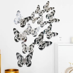 Detailed view of silver hollow butterfly wall decals with floral cutout patterns on white wall