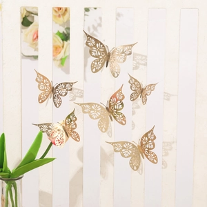 Detailed view of hollow gold paper butterflies with laser-cut patterns on white background