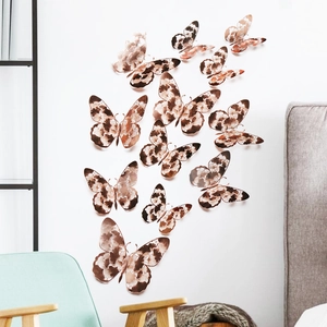 Detail of 12pcs 3D butterfly wall stickers with metallic rose gold patterns in a room