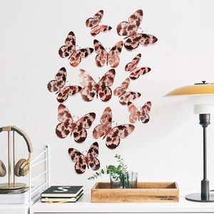 Rose gold 3D butterfly wall stickers with intricate floral cutout patterns on a white wall