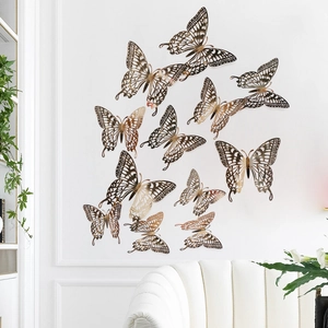 Macro shot of gold 3D hollow paper butterflies with metallic texture on white wall