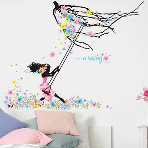 Adesivo murale creativo con una ragazza sull'altalena con fiori colorati e rami d'albero