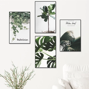 Detail of four-piece Nordic wall art set featuring tropical green leaves and black frames