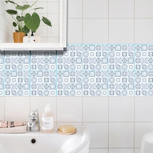 Detail of blue geometric tile stickers on kitchen backsplash with faucet and plant