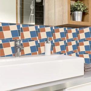 Dettaglio di adesivi per piastrelle geometriche blu e gialle su una parete del bagno