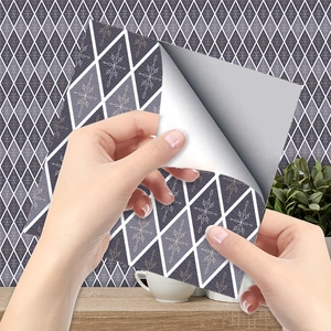 Close-up of peeling the self-adhesive backing of blue geometric diamond tile wallpaper