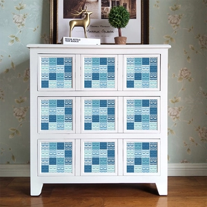 Blue and white geometric tile stickers with heart patterns on a white drawer unit