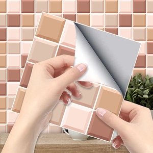 Detail shot showing hand peeling the adhesive backing of orange plaid tile stickers