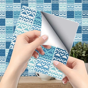 Detail of self-adhesive blue geometric tile sticker being applied to a kitchen wall surface