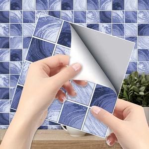 Close-up of hand peeling adhesive backing of purple marble tile sticker for home decor