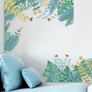 Nordic tropical leaf and flower wall decal set displayed over a light blue sofa on a white wall