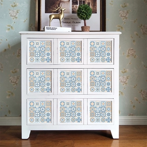 Detail of vintage blue and orange floral tile stickers on white drawer panels