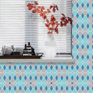 Détail de stickers muraux géométriques bleus et gris appliqués sur un mur de salle de bain