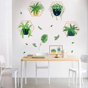 Detail showing Nordic style green plants and golden hexagonal frames on a dining wall