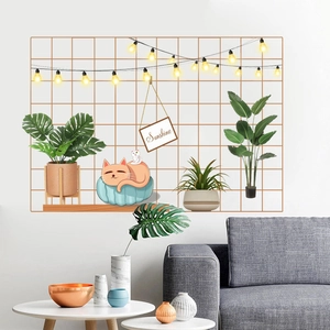 Detail of golden grid wall sticker with cat, plants, and warm LED string lights