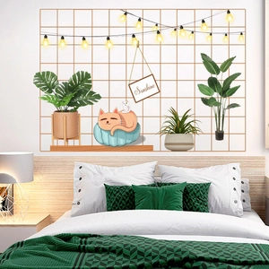 Cozy wall decal detail with wire grid, warm string lights, cat, and plants for bedroom decor