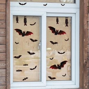 Halloween window stickers featuring black bats with red wings on a glass pane