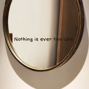 Inspirational Nothing is ever too late wall decal on a stylish round mirror