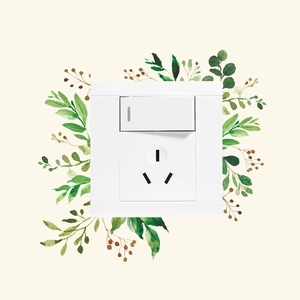 Detail of white light switch and socket with green leaf sticker decoration on wall