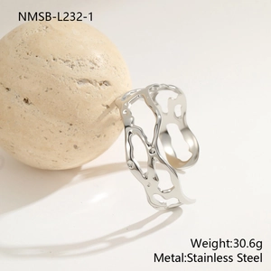 Macro detail of silver geometric hollow stainless steel bangle with organic liquid metal texture