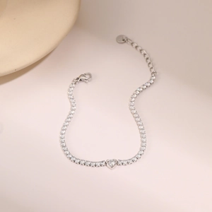 Detalle de una pulsera tennis de corazón en oro de 18K con brillantes circonitas