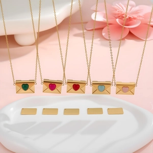 Details goldener Umschlaghalsketten mit bunten Herzanhängern und Metalleinlegeplatten