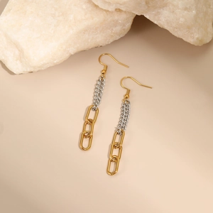 Détail de boucles d'oreilles à pompon long avec chaîne bicolore et maillons polis