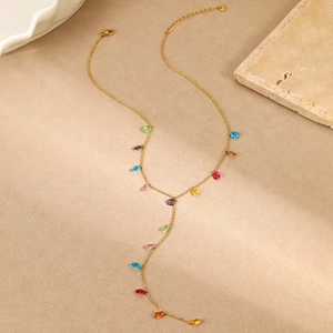 Detalle de collar en Y dorado con piedras facetadas multicolores y colgantes finos
