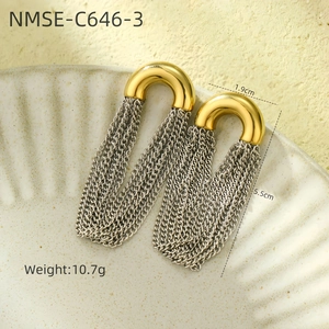 Vue macro détaillée des boucles d'oreilles U-ring dorées avec des glands de chaîne argentée