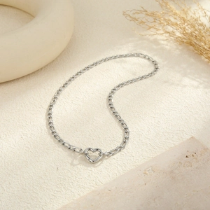 Collana Figaro in acciaio inossidabile lucido con chiusura a cuore su sfondo neutro