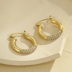 Vista detallada de pendientes de aro en forma de C bañados en oro 18K con piedras de circón