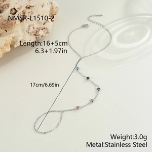 Detailansicht eines silbernen Edelstahl-Ringarmbands mit fünf farbigen Edelsteinen auf beigem Grund