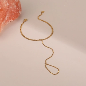 Dettaglio del bracciale anello dorato con dischi circolari e chiusura a moschettone