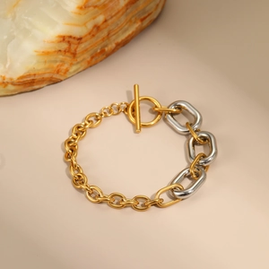 Primer plano de pulsera de cadena bicolor oro y plata con elegante cierre de barra T