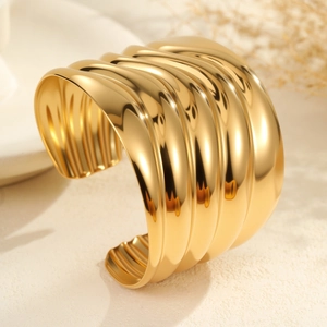 Brazalete abierto ancho de acero inoxidable con ondas cóncavas en acabado dorado espejo