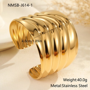 Detalle del brazalete cóncavo ancho de acero inoxidable con acabado de espejo dorado