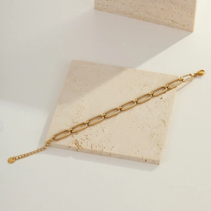 Macro shot of gold paperclip chain bracelet with zirconia inlays and lobster clasp closure