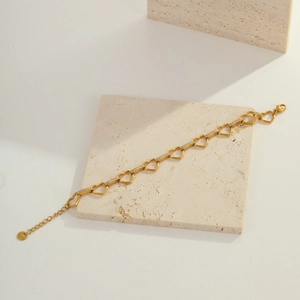 Detail of gold-plated heart chain bracelet with white zircons and lobster clasp closure