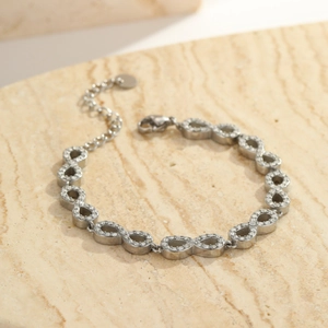 Macro shot of silver infinity link bracelet with pavé cubic zirconia and lobster clasp