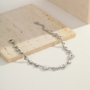 Detailed view of silver heart bracelet with cubic zirconia charms and lobster clasp