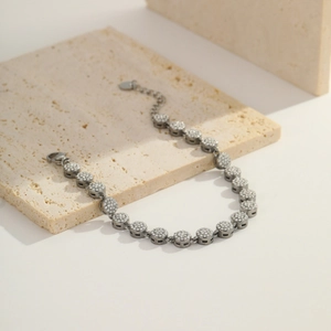 Macro shot of silver-tone chain featuring circular rings paved with white cubic zirconia