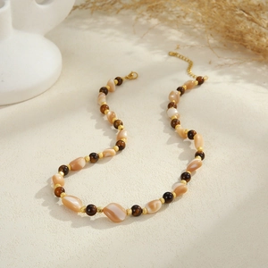 Detail of bohemian starfish necklace with shell beads and golden lobster clasp
