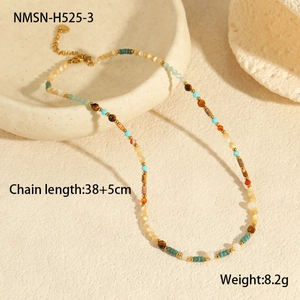 Detail of bohemian colorful beaded necklace with gold extension chain on ceramic