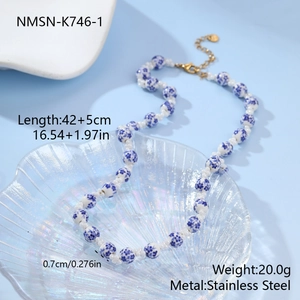 Detail view of floral ceramic beads and white pearls with stainless steel lobster clasp