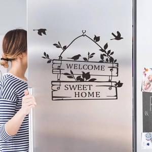 Welcome Sweet Home wall sticker with birds and vine silhouette on a stainless fridge
