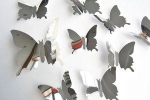 Macro detail of 3D silver mirror butterfly wall stickers with foldable wings for decoration