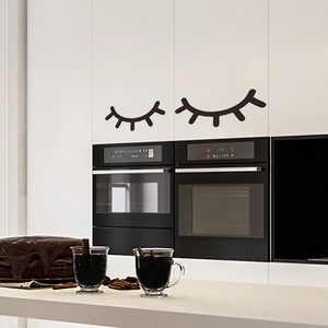 Close-up of black eyelash wall decals applied on a modern white kitchen cabinet