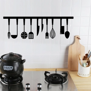 Detail of black PVC kitchen wall stickers with cutlery silhouette on white tiles